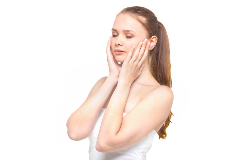両手を頬にあてる女性